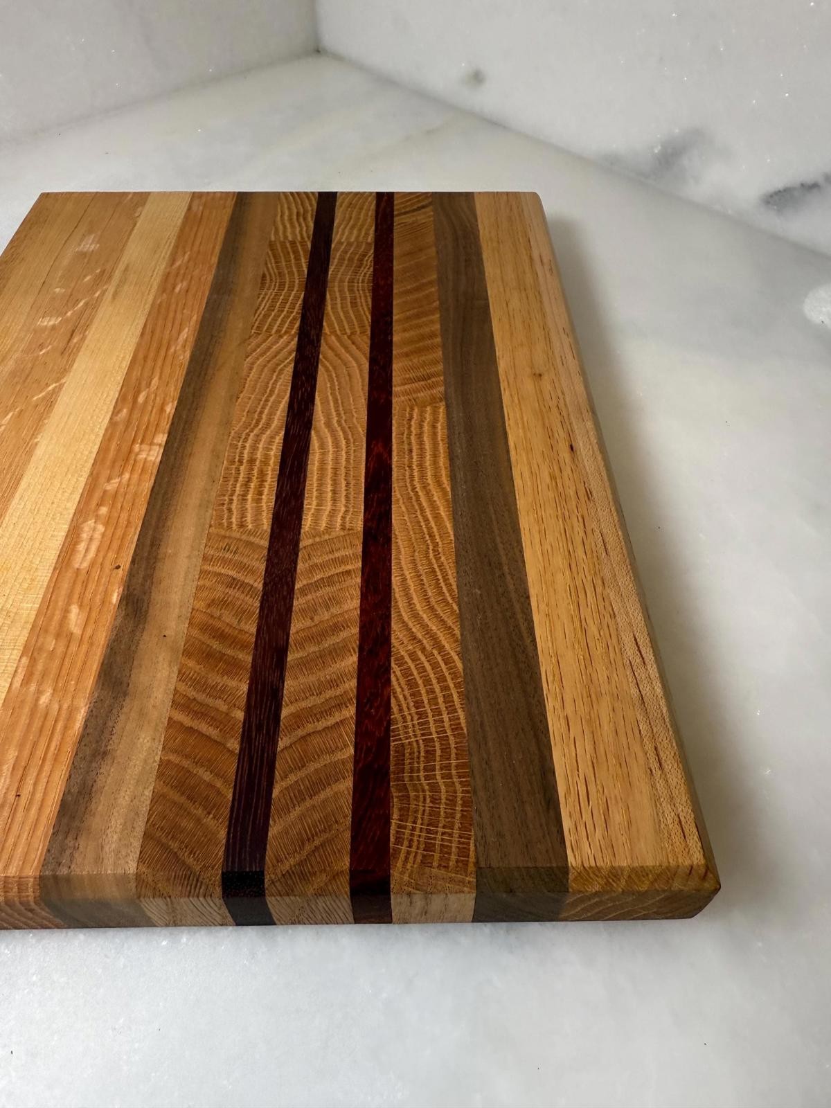 Large edge grain charcuterie cutting board made of multiple hard wood types