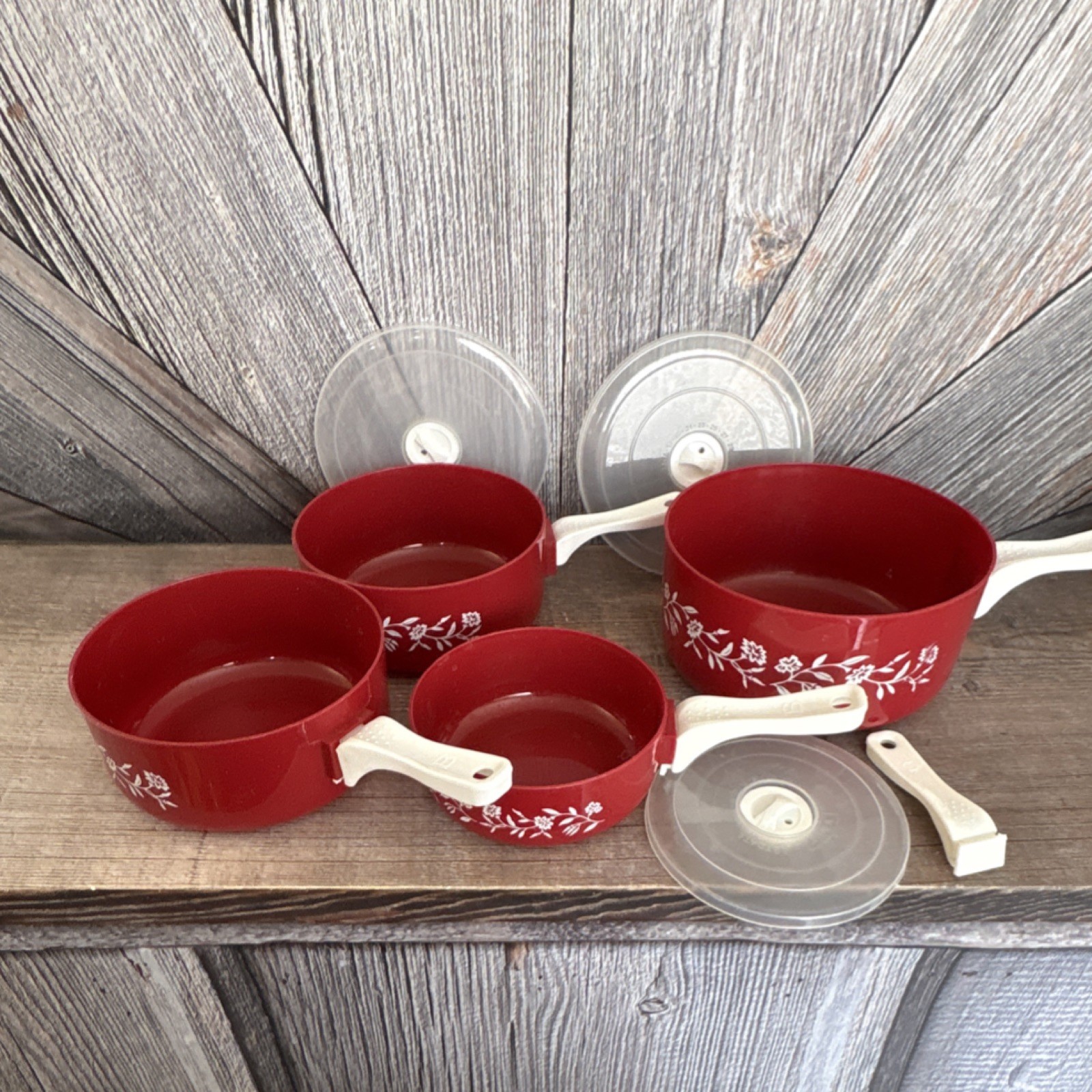 Red Floral Plastic Four-Piece Saucepan Set with Lids and White Handles
