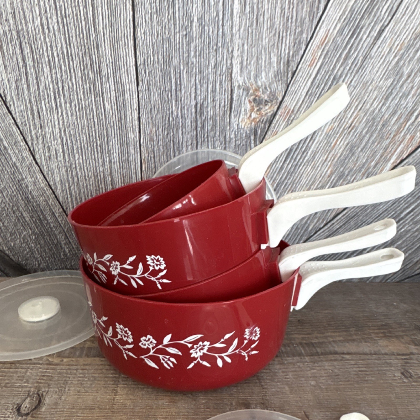 Red Floral Plastic Four-Piece Saucepan Set with Lids and White Handles
