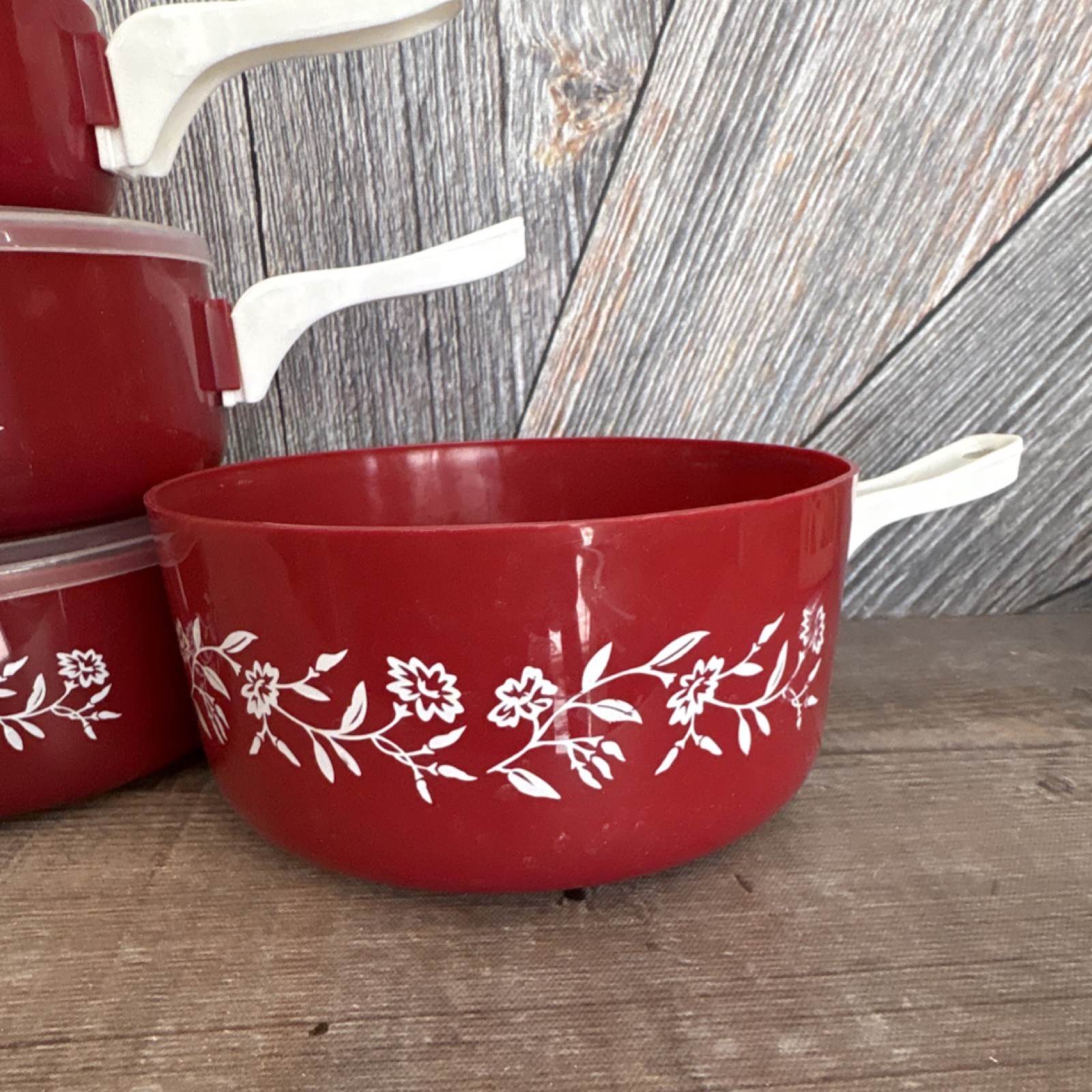 Red Floral Plastic Four-Piece Saucepan Set with Lids and White Handles